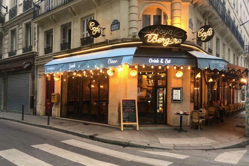 Entoilage stores bannes et store pantographe avec lambrequins lumineux et guirlandes guinguette avec ampoules ambré du restaurant Le Royal Bergère à Paris